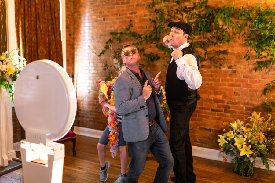 Guys dancing in front of photo booth at tasting party / Whimsical / Summer / August / Yellow / Lavender / Blush